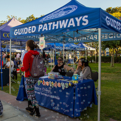 Guided Pathways staff members attend a booth during an event at Fullerton College.
