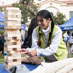 A Fullerton College student plays Jenga during a campus event.