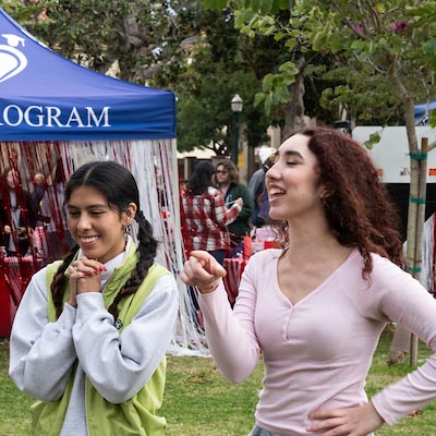 Two Fullerton College students laugh together during a campus event.