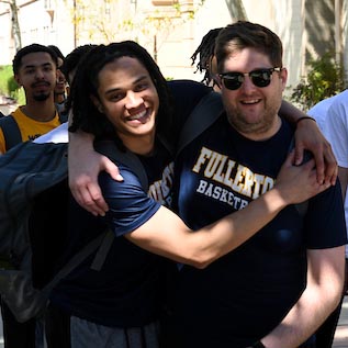 Two Fullerton College students embrace in celebration after an event.