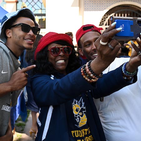 Three Fullerton College students take a selfie during an event on campus.