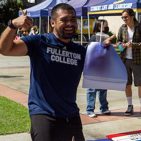A Fullerton College student shows off his muscles during a campus event.